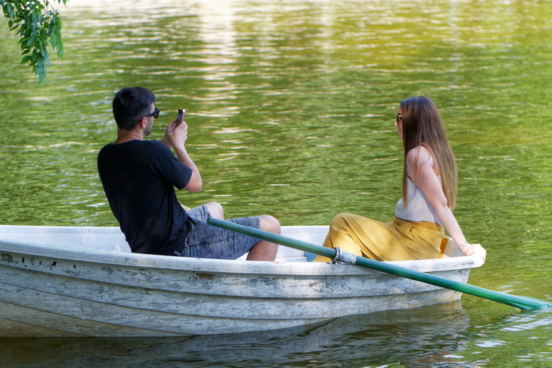 22 - Two individuals enjoying a boat ride together on a calm, green lake